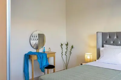 a bedroom with a bed and a mirror on a table at Ionia Cozy Home in Chania Town