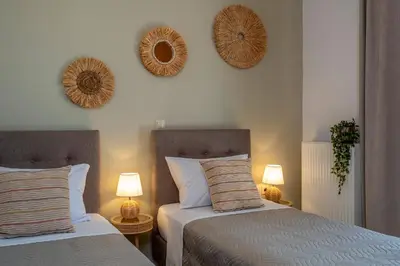 two beds in a bedroom with two mirrors on the wall at Armeria Apartments I I in Daratso