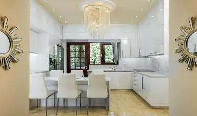 a kitchen with white cabinets and a chandelier at Pandis Palace in Agios Onoufrios
