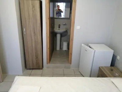 a person taking a picture of a bathroom with a sink at Ελευθέριος rooms 2 in Chania Town