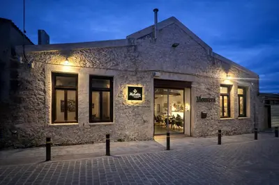 a brick building with a store window at night at Endless blue suites 3 in Chania Town
