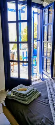 a bed in a room with a large window at Erofili Apartment in Kalyves