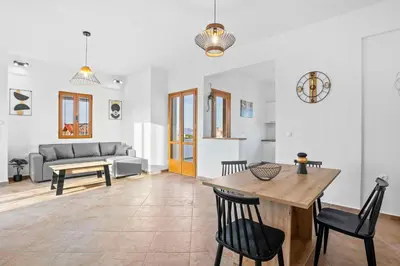 a living room with a table and chairs and a couch at 2 bd sea view sun terrace apartment 500 meters walk to the beach in Galatás