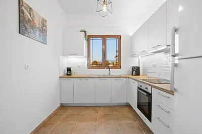 a white kitchen with a sink and a window at 2 bd sea view sun terrace apartment 500 meters walk to the beach in Galatás