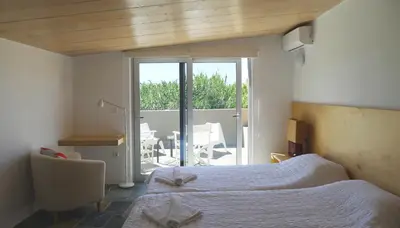 a bedroom with a bed and a balcony with a table at Proimos Apartments in Gerani Chanion