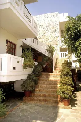 a white house with stairs and potted plants at Proimos Apartments in Gerani Chanion