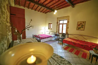 a living room with a room with a bed and a candle at Picturesque Traditional Stone House in Plátanos