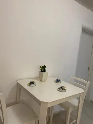 a white table and chairs with a potted plant on it at Be Crete - Zen apartment 2 rooms in Ayiá