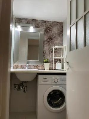 a bathroom with a sink and a washing machine at Be Crete - Zen apartment 2 rooms in Ayiá