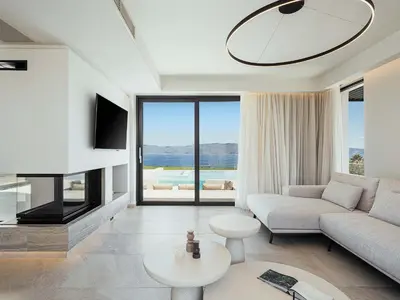 a living room with a couch and a tv at Rastoni Villa I ''Free'' heated pool & panoramic view in Kalivianí