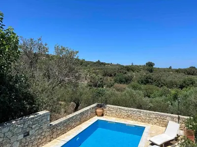 a swimming pool in a stone wall next to at Perfect home away from home in Palio Gerani