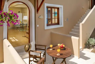a patio with a table and chairs and stairs at Avra Apartments in Kalyves