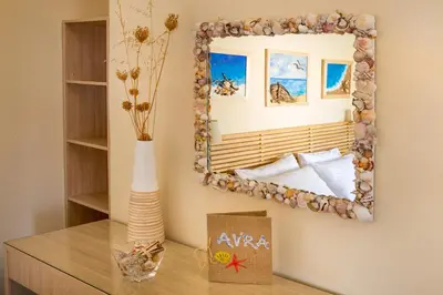 a mirror on a wall next to a table at Avra Apartments in Kalyves