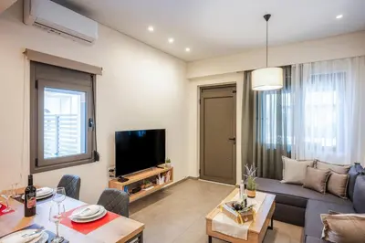a living room with a couch and a tv at Erato - Newly renovated Home with Parking in Chania Town