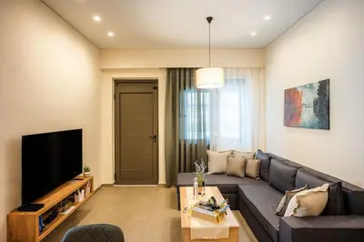 a living room with a couch and a tv at Erato - Newly renovated Home with Parking in Chania Town