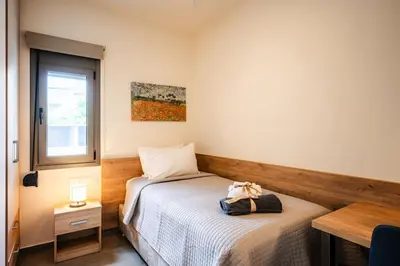 a bedroom with two beds and a window at Erato - Newly renovated Home with Parking in Chania Town
