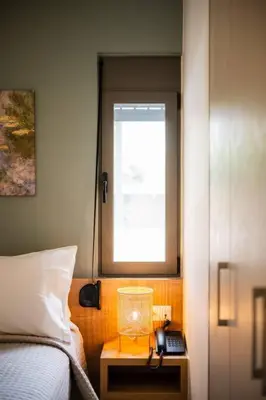 a bedroom with a bed and a window and a phone at Erato - Newly renovated Home with Parking in Chania Town