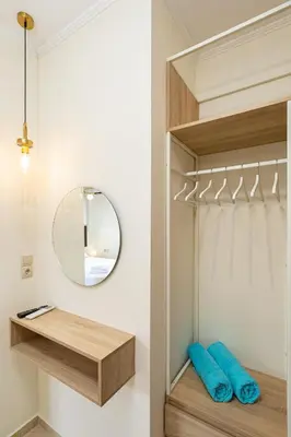 a walk in closet with a mirror and blue pillows at Villa Mari mini in Kondópoula