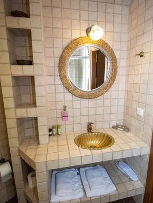 a bathroom with a gold sink and a mirror at Elia Portou Rooms in Chania Town