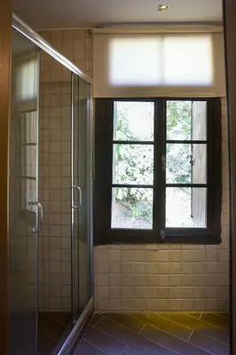 a bathroom with a glass shower and a window at Elia Portou Rooms in Chania Town