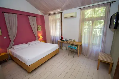 a bedroom with a bed and a desk and a window at Elia Portou Rooms in Chania Town