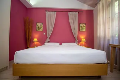 a bedroom with a large bed with purple walls at Elia Portou Rooms in Chania Town