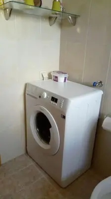 a washing machine in the corner of a bathroom at COSY NEW APARTMENT- 5' to the beach, 15' to center in Chania Town