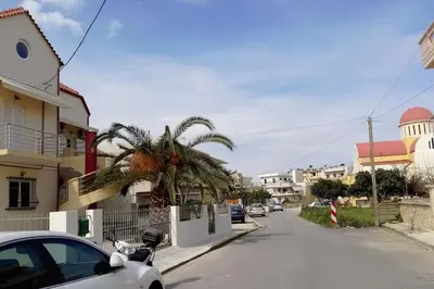a car parked on the side of a street with a palm tree at COSY NEW APARTMENT- 5' to the beach, 15' to center in Chania Town