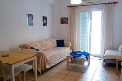 a living room with a couch and a table at COSY NEW APARTMENT- 5' to the beach, 15' to center in Chania Town