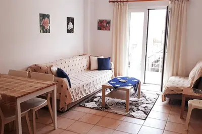 a living room with a couch and a table at COSY NEW APARTMENT- 5' to the beach, 15' to center in Chania Town