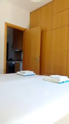 a kitchen with a white counter top and wooden cabinets at QUIET NEW Apartment-5' to the beach, 15' to center in Chania Town