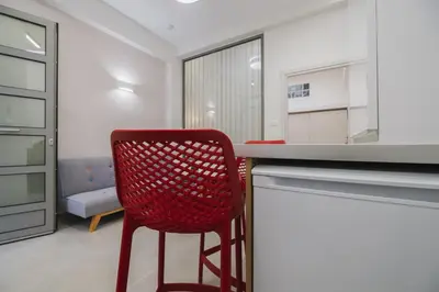 a red chair sitting at a counter in a kitchen at Peris 4 with Yard steps to Old Town - AC, Wifi in Chania Town
