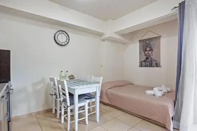 a room with a bed and a table and chairs at Dimi's Studio Center in Chania in Chania Town