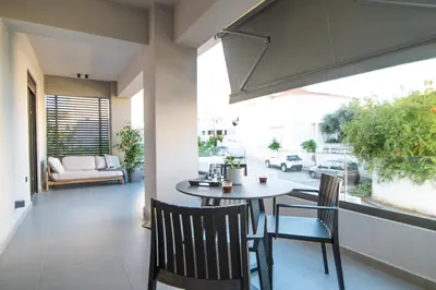 a dining room with a table and chairs on a balcony at A3stays a cozy vacation retreat in Chania Town