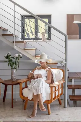 a woman sitting in a chair under a staircase at Villa Shell in Tersanas