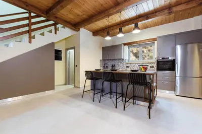 a kitchen with a center island with bar stools at Villa Kalithea in Kissamos