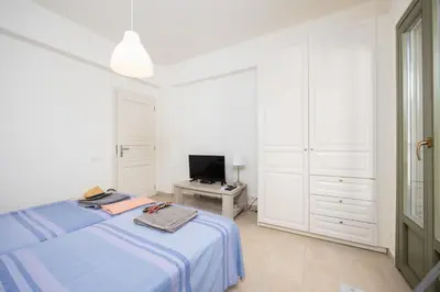 a white bedroom with a bed and a television at Villa Nafsika in Vamos