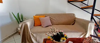 a living room with a couch and a table with flowers at Sky & Sea 3 in Kato Daratso