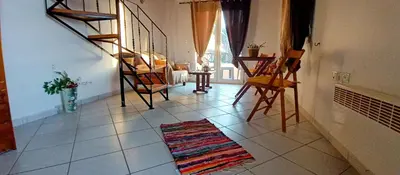 a living room with stairs and a rug on the floor at Sky & Sea 3 in Kato Daratso