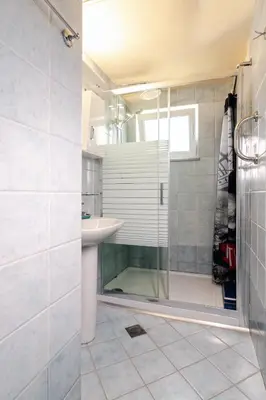 a bathroom with a glass shower and a sink at Alena Apartments in Chania Town