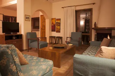 a living room with couches and a table and a tv at Aori Hillside Villa in Kántanos