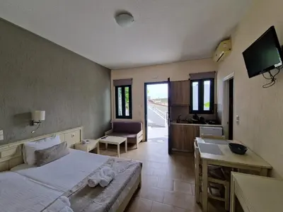 a bedroom with a bed and a desk and a kitchen at Rainbow Hotel Apartments in Chania Town