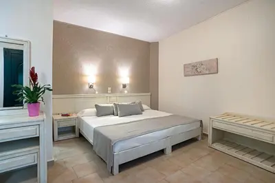 a bedroom with a large bed and two tables at Rainbow Hotel Apartments in Chania Town