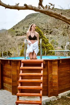 a woman in a bikini sitting on a ladder at Elafonisi - Cretan Serenity - Private Pool in Elafonisi