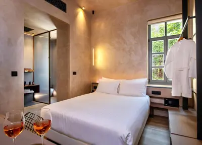 a bedroom with a bed and two glasses of wine at Nearchou Boutique Hotel in Chania Town