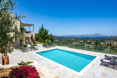 a swimming pool with a view of a villa at Villa Anthos - Superb panoramic sea and hill views with private pool in Gavalochori