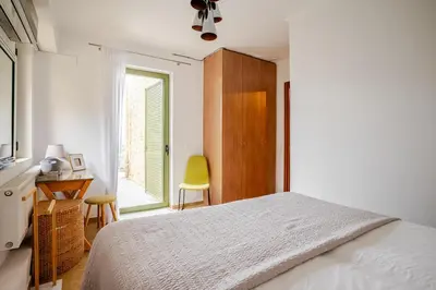 a bedroom with a bed and a desk and a window at Villa Anthos - Superb panoramic sea and hill views with private pool in Gavalochori