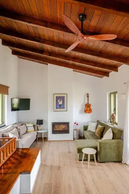 a living room with a ceiling fan and a couch at Villa Anthos - Superb panoramic sea and hill views with private pool in Gavalochori