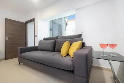 a gray couch with two glasses of wine at Kappa Apartment in Chania Town