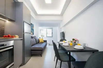 a kitchen and living room with a table and a couch at Kappa Apartment in Chania Town